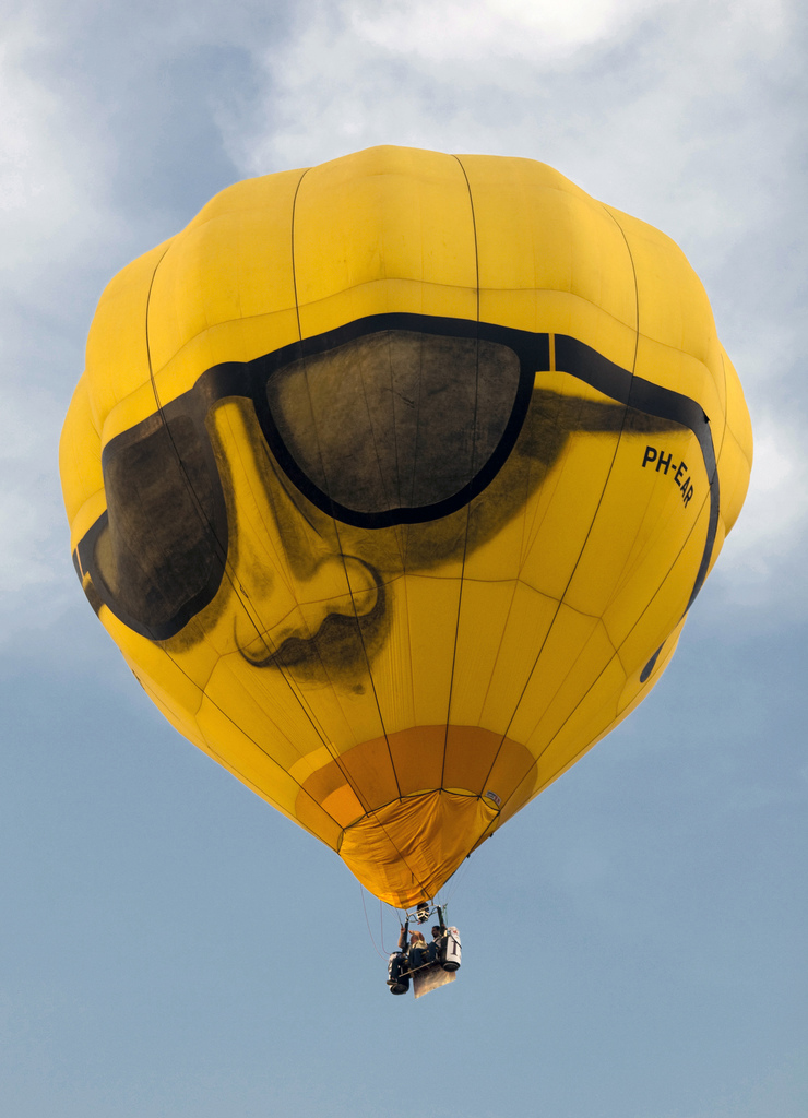 The air inside this hot air balloon flying over Putrajaya, Malaysia, is hotter than the ambient air. As a result, the balloon experiences a buoyant force pushing it upward. (credit: Kevin Poh, Flickr)